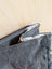 Dark gray denim wallet with frayed edges and zipper pull from the matty affair canvas and angus oliver collection