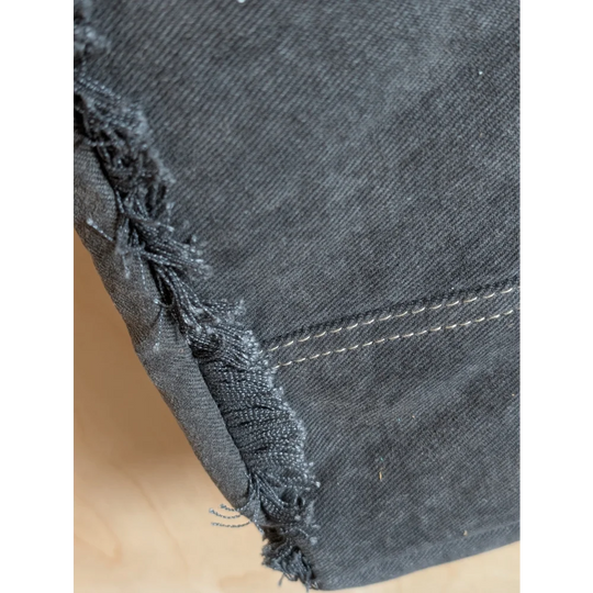 Dark gray denim fabric with frayed edges and white stitching on matty affair canvas weekender bag by angus oliver