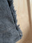 Dark gray denim fabric with frayed edges and white stitching on angus oliver matty affair canvas weekender bag