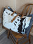 A black and white cowhide #6 matty affair canvas tote bag with tan leather straps and brown leather trim by angus oliver