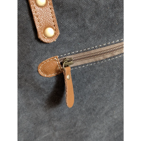 Tan leather zipper pull with metallic slider and brass studs on matty affair canvas weekender bag by angus oliver