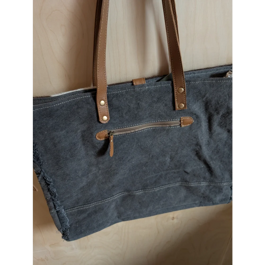 Dark blue denim weekender bag with brown leather straps and zipper accents made from matty affair canvas by angus oliver