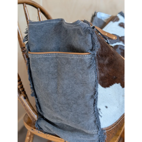 A rugged dark gray denim pouch with frayed edges and tan leather trim from angus oliver matty affair canvas collection