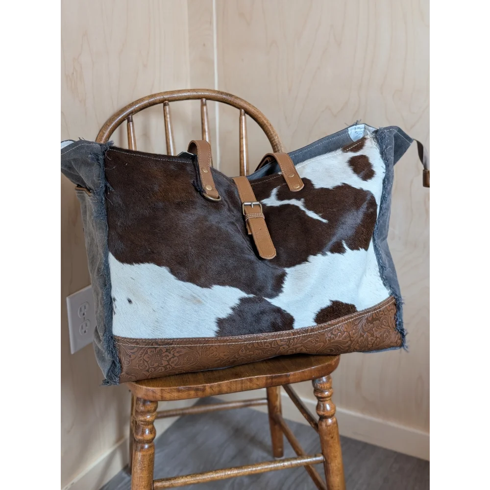 Brown and white cowhide shoulder bag with tan leather straps and embossed base from angus oliver matty affair canvas line