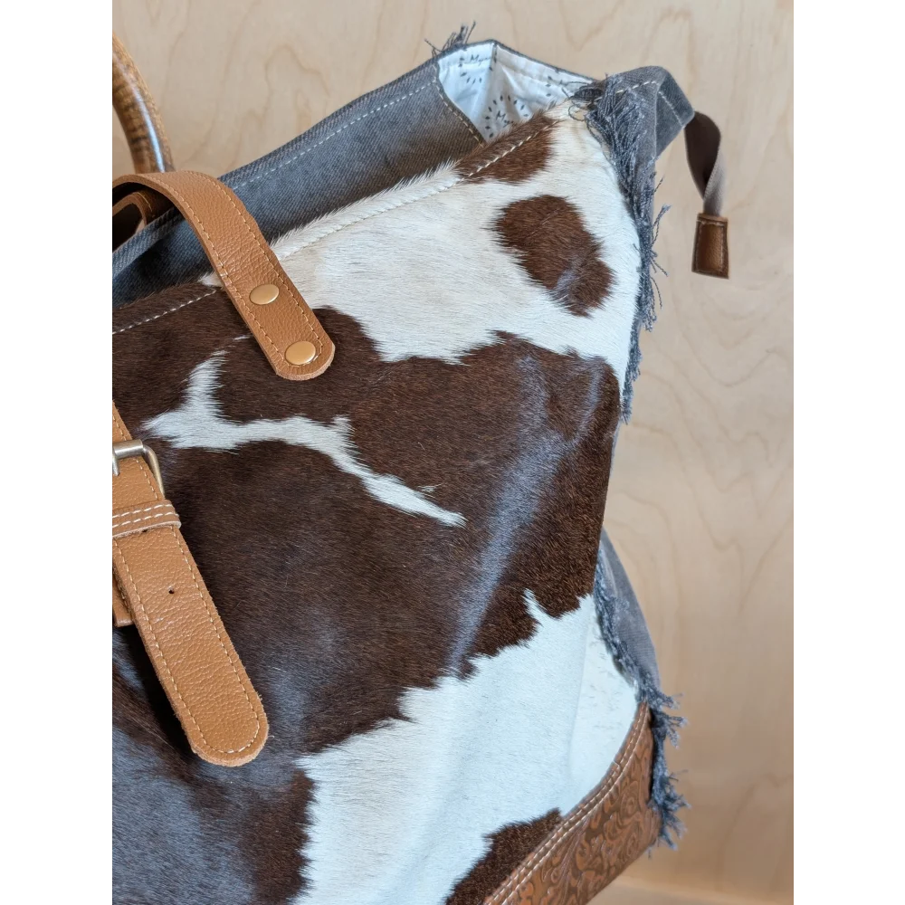 Brown and white cowhide weekender tote bag with tan leather straps from matty affair canvas by angus oliver