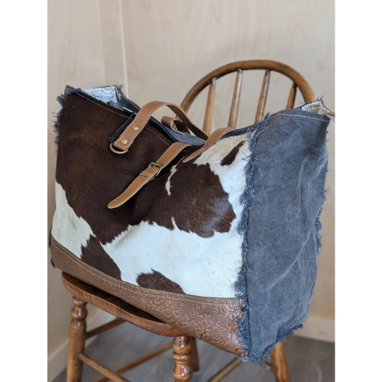 Brown and white cowhide shoulder bag with distressed denim and tan leather straps from angus oliver matty affair canvas collection