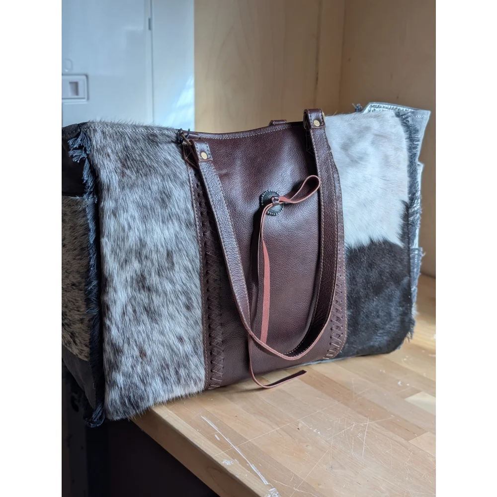 Brown leather weekender bag with beautiful hair-on hide contrast panels in gray white and black by angus oliver