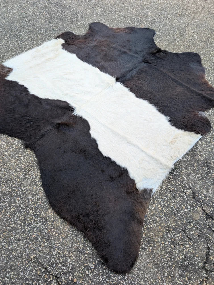 A large black and white natural cowhide rug with soft fluffy texture showcasing unique characteristics for beautiful rugs