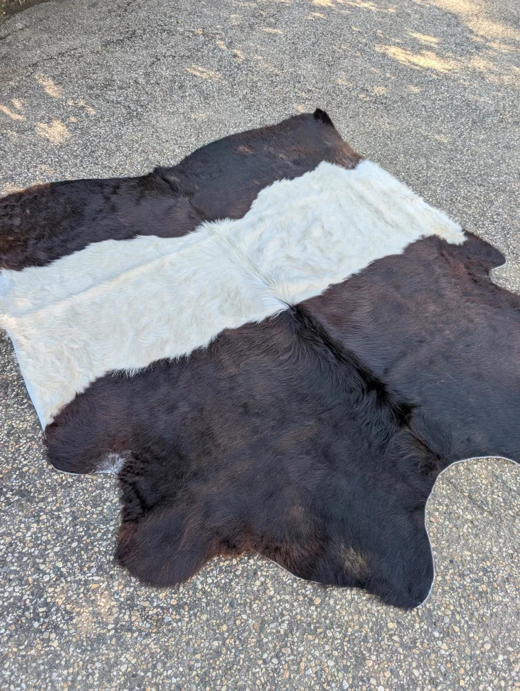 A large cowhide rug with unique black and white pattern and soft fur featuring beautiful rugs for home decor