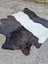 A large black and white belted galloway cowhide rug with soft fluffy texture showcasing unique characteristics