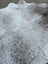 Large cowhide rug with unique characteristics in a mottled white and gray pattern adding rustic charm to any room