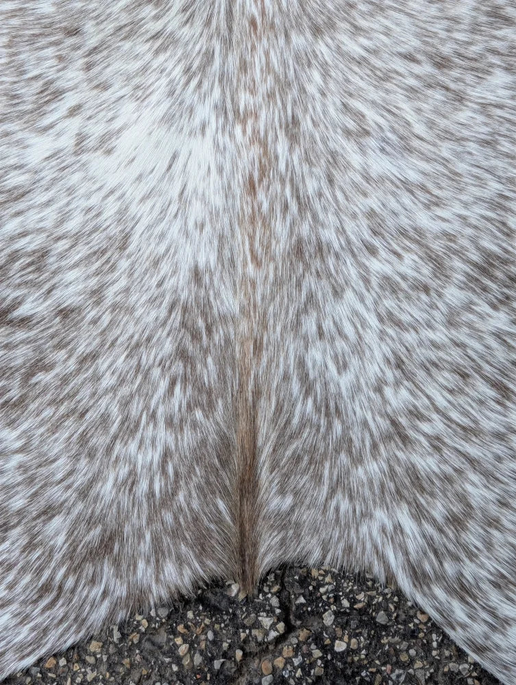 A large 89 x 77 inch grey mix #7 cowhide rug with white and gray speckled fur and unique rustic charm