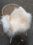 Fluffy natural white icelandic sheepskin long wool throw draped over a wicker chair for cozy decor