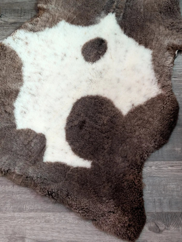 Brown and white highland spotted grade a- sheepskin rug with natural irregular shape for cozy home decor