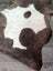Brown and white highland spotted grade a- sheepskin rug with natural irregular shape for cozy home decor