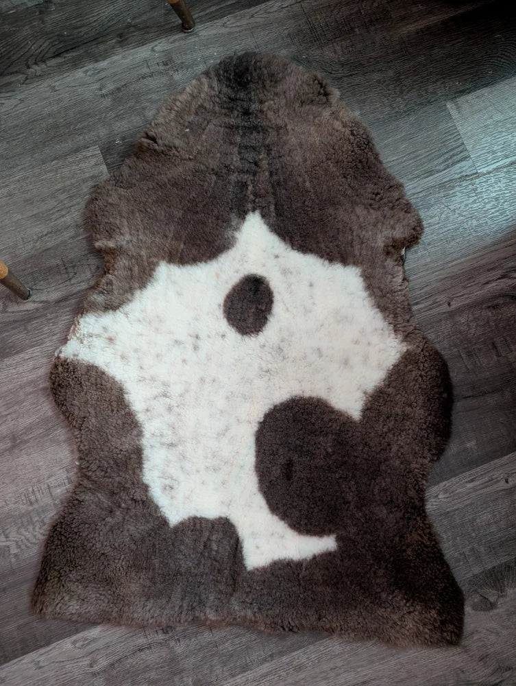 Brown and white highland spotted grade a- sheepskin rug with natural irregular shape perfect for cozy decor