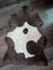 Brown and white highland spotted grade a- sheepskin rug with natural irregular shape perfect for cozy decor