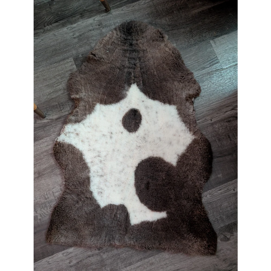 Brown and white highland spotted grade a- sheepskin rug with natural irregular shape perfect for cozy decor