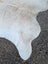 A large off-white cowhide rug 92 x 81 with unique characteristics and rustic charm in soft textured material