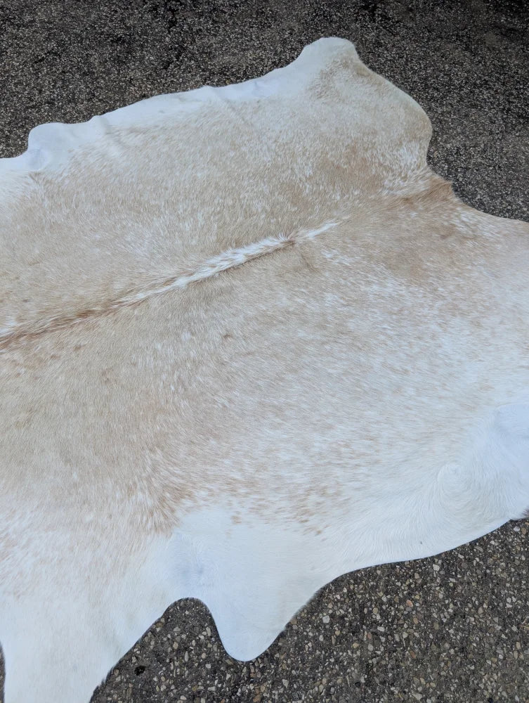 92 x 81 large cowhide rug in off white with subtle tan patches featuring unique characteristics and rustic charm