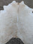 A large cowhide rug 92 x 81 with natural off-white color and subtle tan markings showcasing unique characteristics and rustic charm