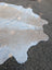A large cowhide rug 98 x 89 inches with soft white and beige fur pattern showcasing unique characteristics and rustic charm