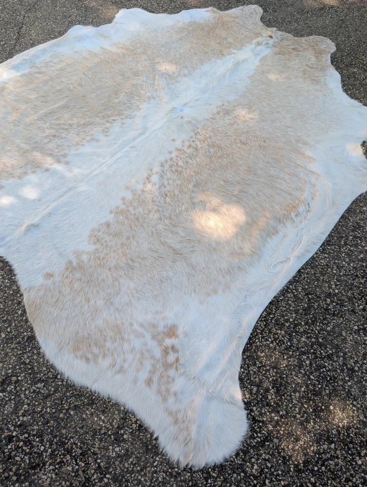 Large cowhide rug in natural white and tan with unique characteristics and rustic charm, soft fluffy texture 98 x 89 inches