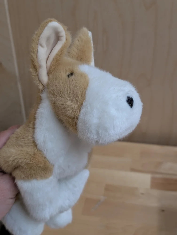 A soft plush adorable corgi puppy puppet with tan and white fur and stitched black eyes and nose
