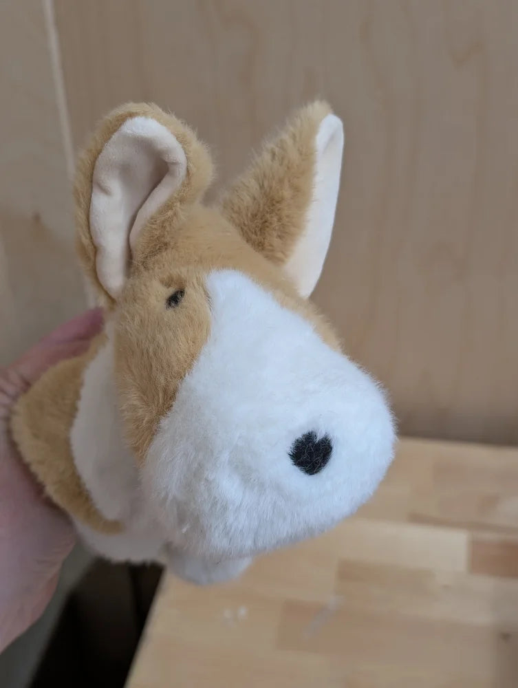 An adorable corgi plush puppet with tan and white fur black button eyes and a stitched nose