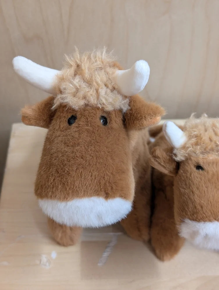 Adorable highland cow brown plush toy with white horns fluffy tan mane black button eyes and white underbelly