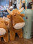 A plush brown highland cow stuffed toy with white horns and fluffy white muzzle perfect for cuddling