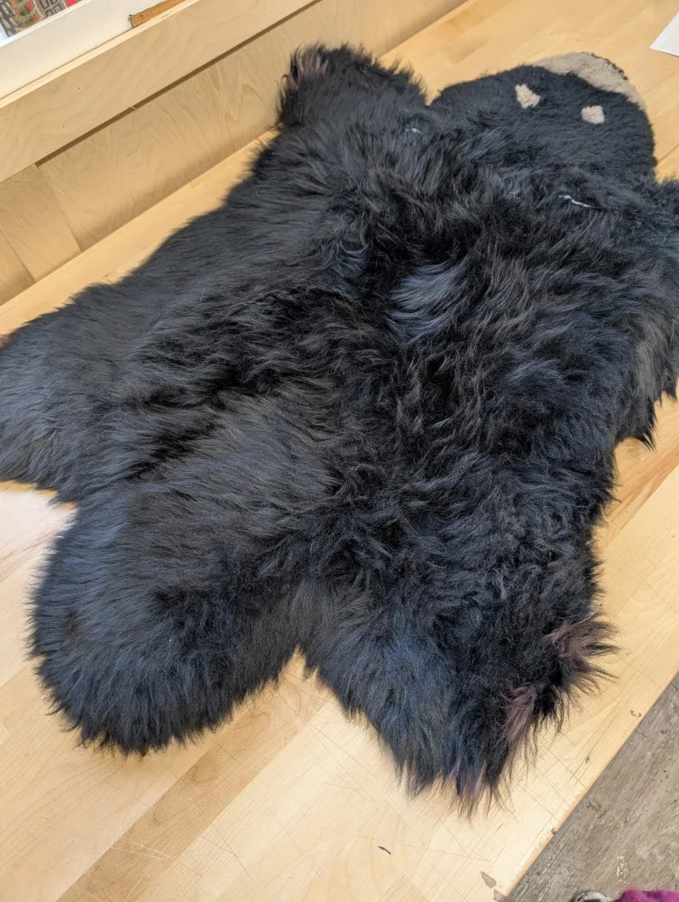 Adorable handmade black bear rug made of soft merino sheepskin perfect as a fluffy animal fur decor piece