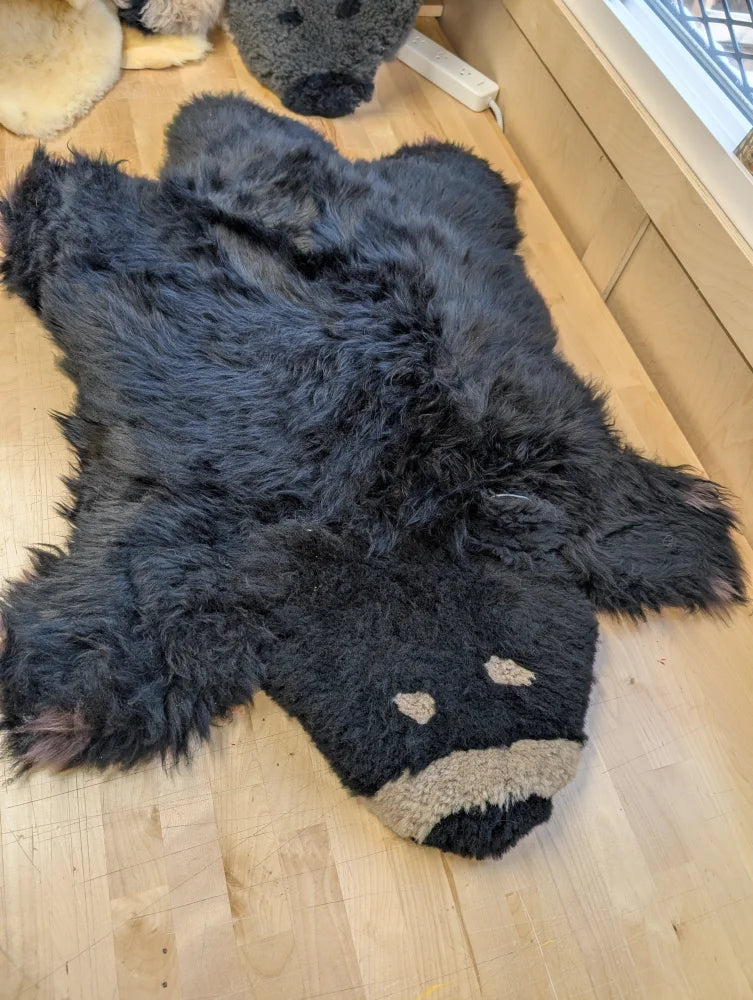 Adorable hand made black bear rug made of soft merino sheepskin with tan nose and eye accents perfect for cozy decor