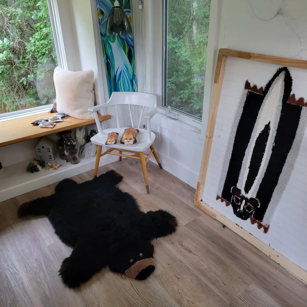 Adorable merino sheepskin black bear rug in faux fur with brown snout and paws perfect for cozy decor