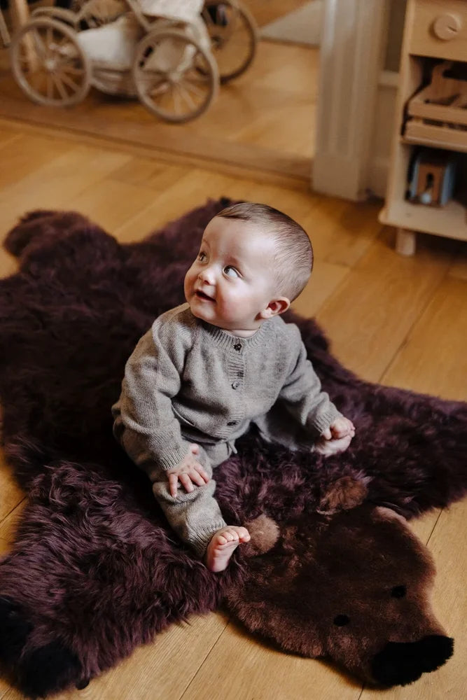 Adorable merino sheepskin grizzly bear rug in dark brown with soft furry texture and black embroidered eyes