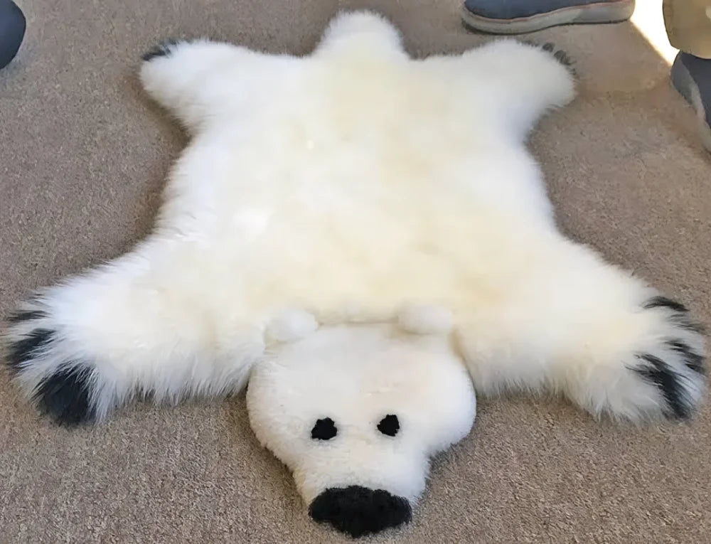 Adorable handmade merino sheepskin polar bear rug with plush white fur and black tipped paws arriving mid october