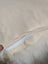 Beige canvas pillow with white zipper and fluffy white interior from adorable set of sheepskin cushions by angus oliver canada