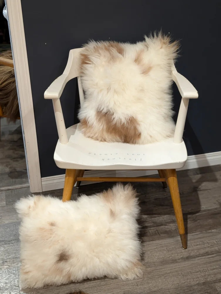 Fluffy cream and beige sheepskin throw pillow on white wooden chair from angus oliver canada sheepskin rugs collection