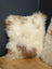 A plush square sheepskin cushion in cream and light brown perfect for cozy angus oliver canada decor
