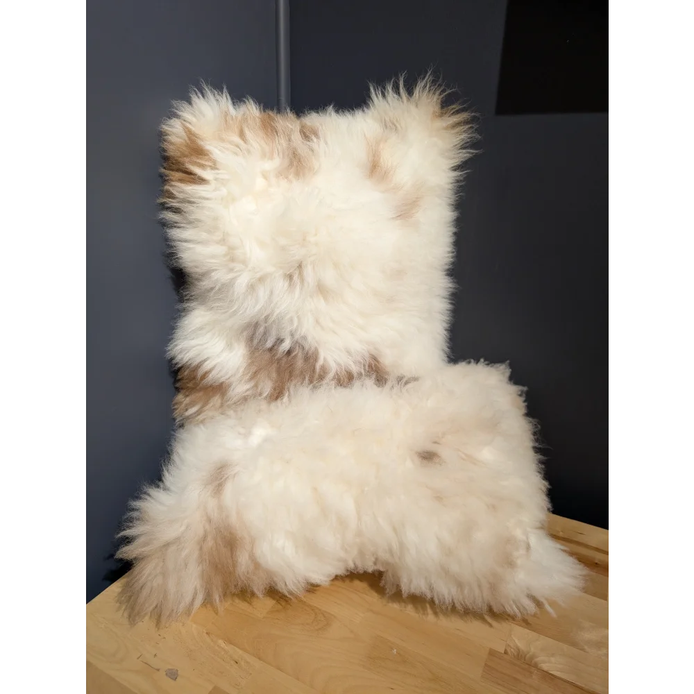 A plush cream and beige sheepskin cushion with a soft textured surface from angus oliver canada collection