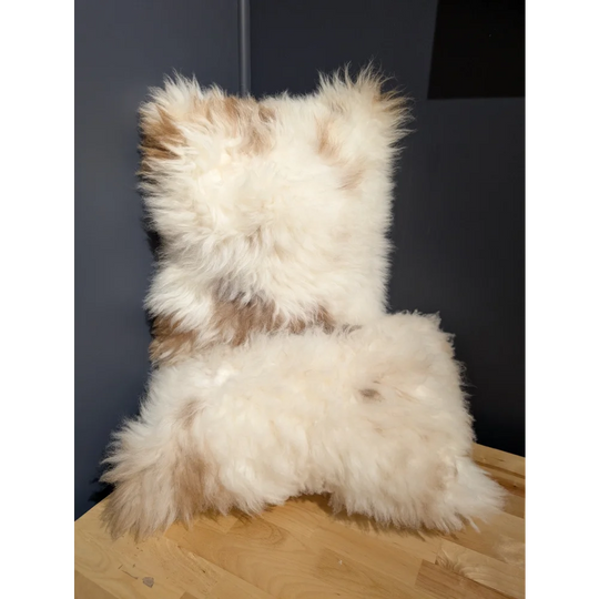 A plush cream and beige sheepskin cushion with a soft textured surface from angus oliver canada collection