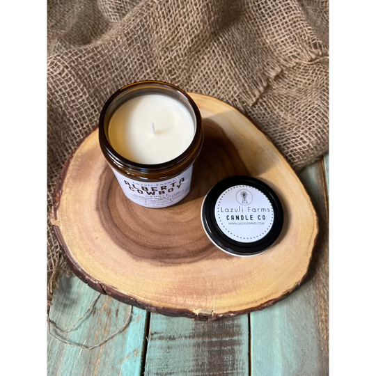White Alberta Cowboy Candle with black label on wooden base
