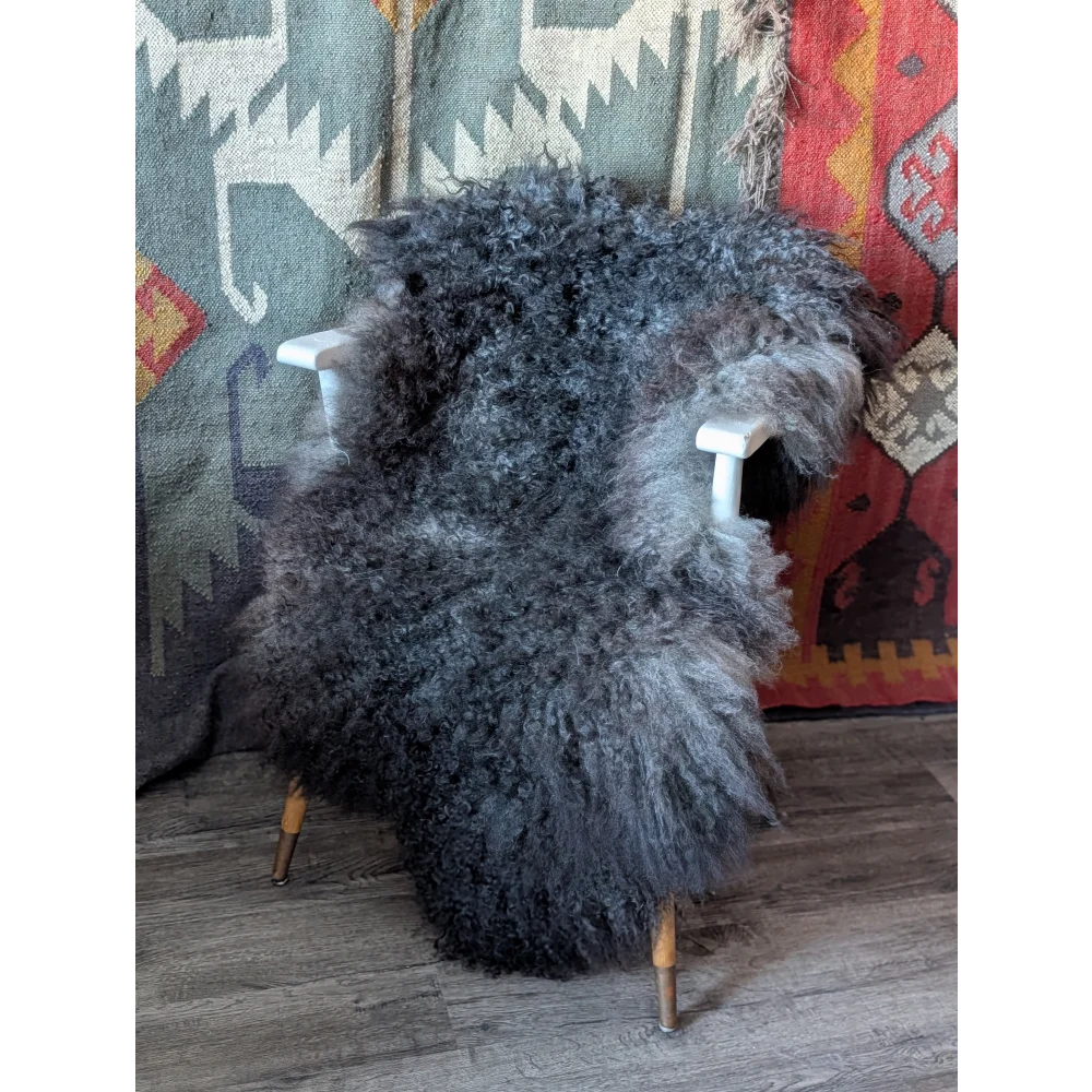 Gotland sheepskin rug draped over white wooden chair, 55x36 plush gray