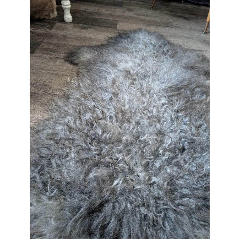 Gotland sheepskin rug, 56x33 plush curly gray on wood floor