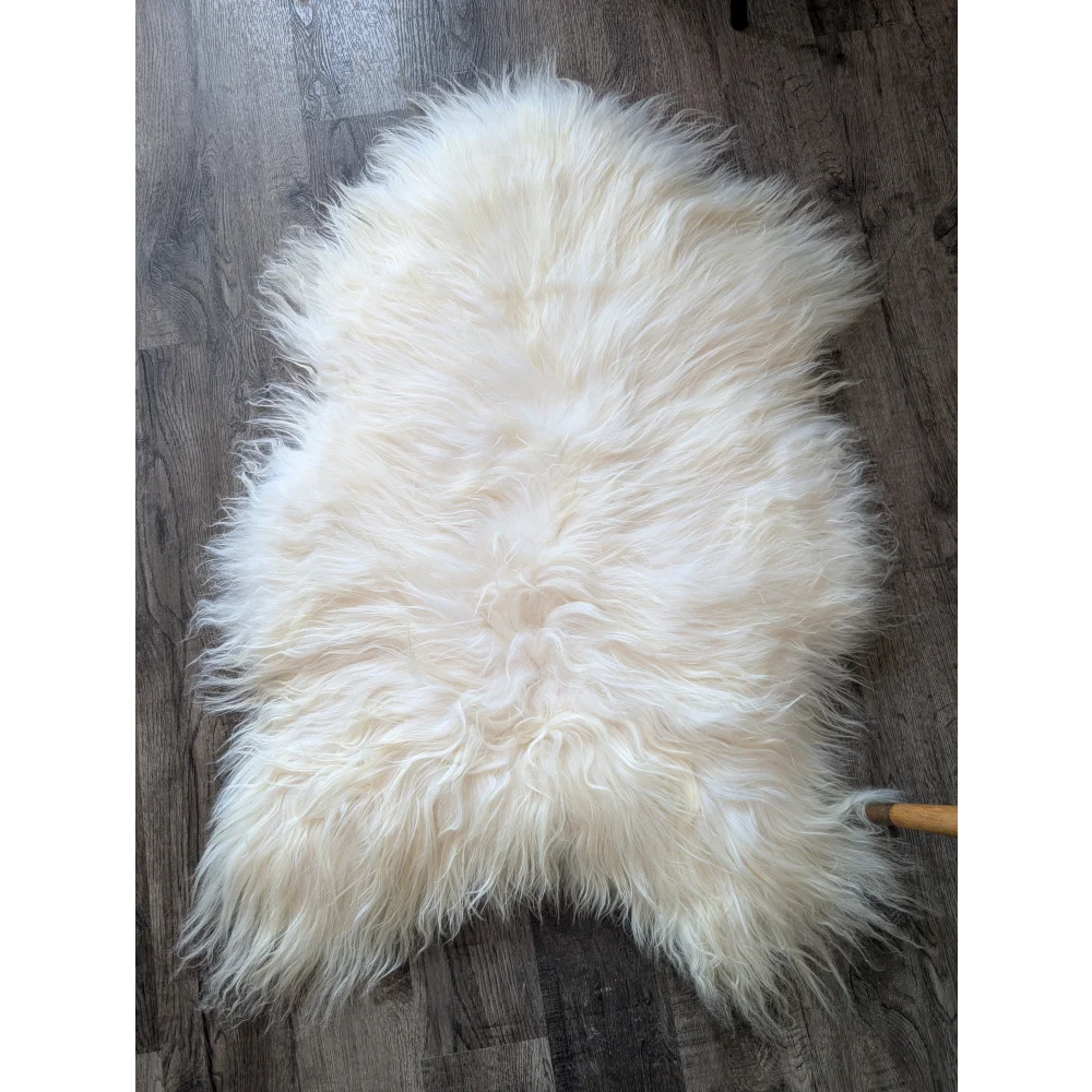 Cream-colored soft Icelandic sheepskin rug 50x34 inches on wood floor