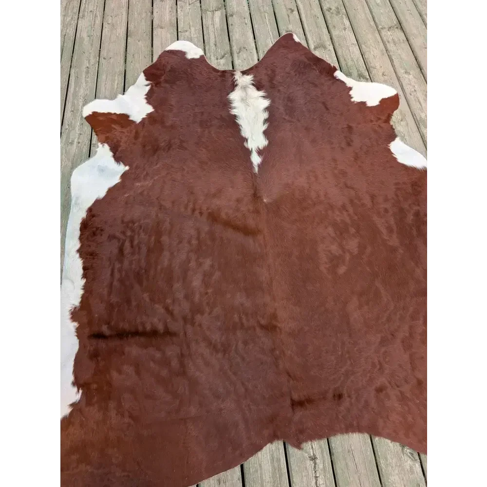 Large 83’’ x 77’’ cowhide rug with brown and white patches, soft underfoot