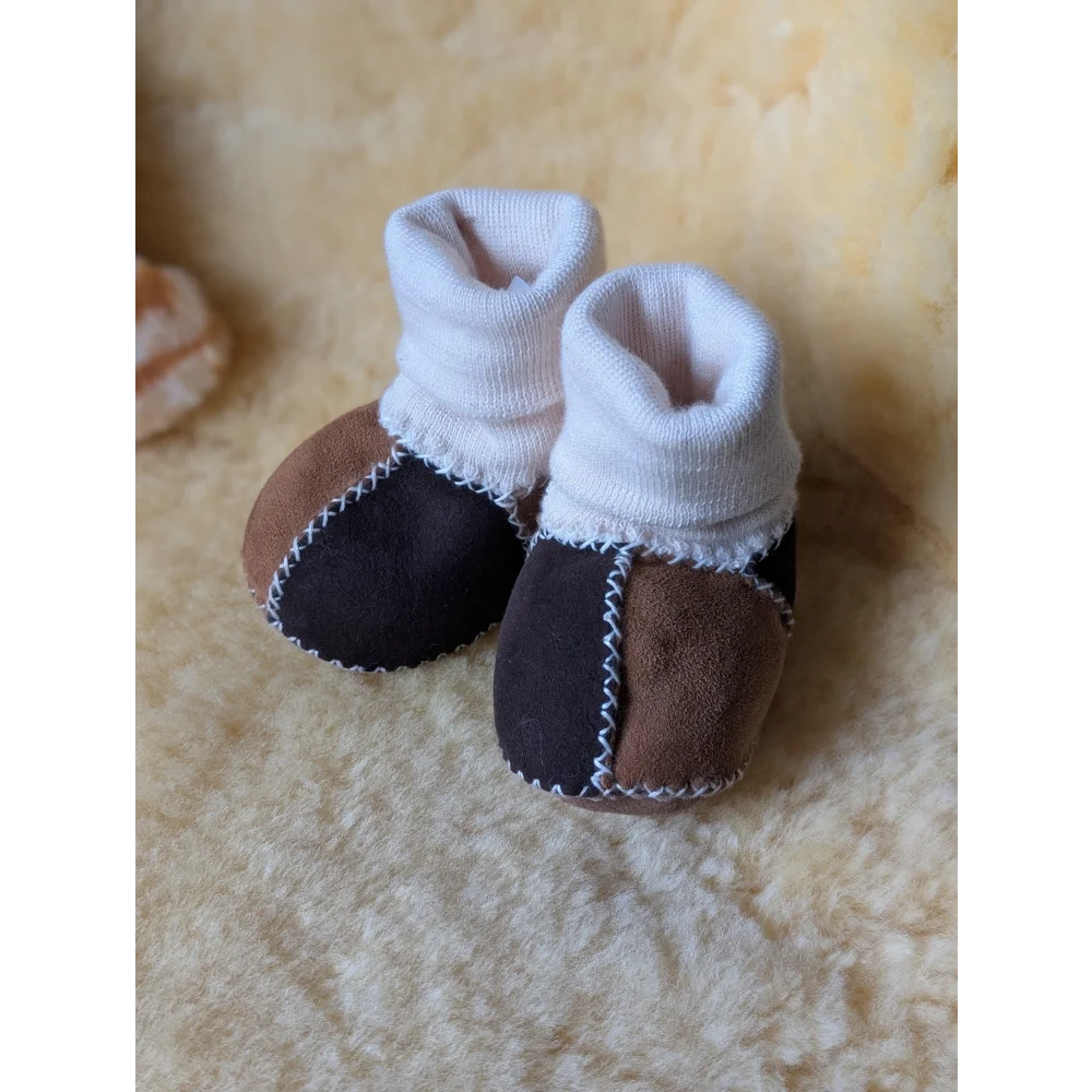 Cute baby booties with white cuffs, made from dense shearling wool and medical sheepskin