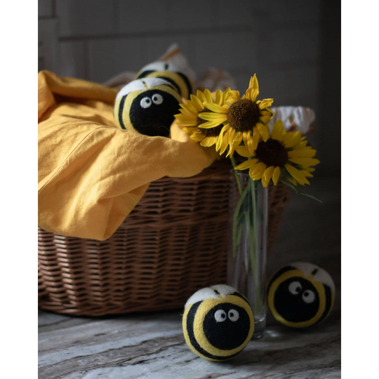 Yellow and black fuzzy bee trio eco dryer balls made of wool with embroidered eyes and storage bag for laundry use