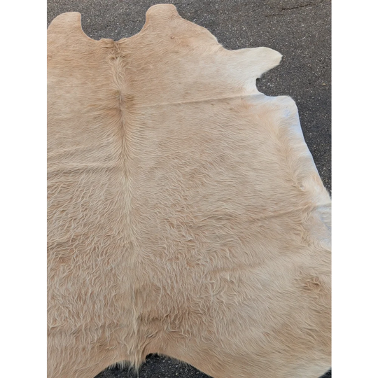 Cream-colored extra large cowhide rug with natural markings and texture for a stylish look