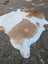 Beigewhite large cowhide rug with brown and white natural patches perfect for adding rustic charm to any room